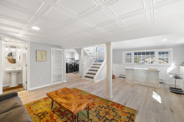 living area with light wood finished floors, baseboards, an ornate ceiling, stairway, and washing machine and dryer