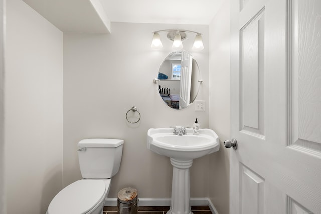 bathroom with toilet and baseboards