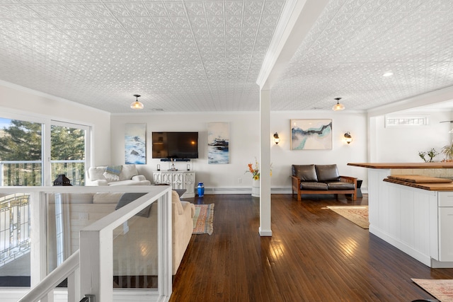 living area with crown molding, baseboards, and dark wood-type flooring