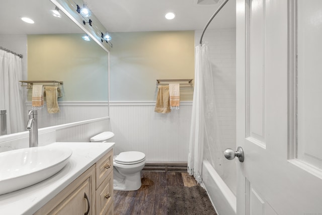 full bathroom featuring toilet, recessed lighting, wood finished floors, vanity, and wainscoting