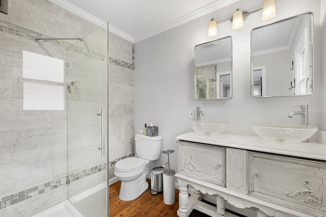 full bathroom featuring a stall shower, ornamental molding, a sink, and wood finished floors