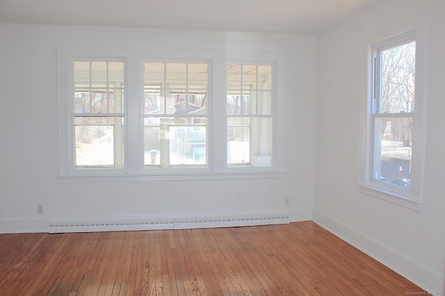 unfurnished room with a baseboard radiator, wood-type flooring, and baseboards