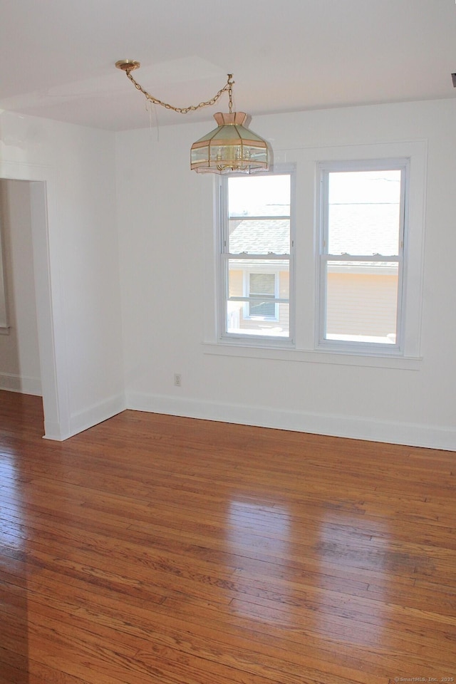 empty room with baseboards and wood finished floors