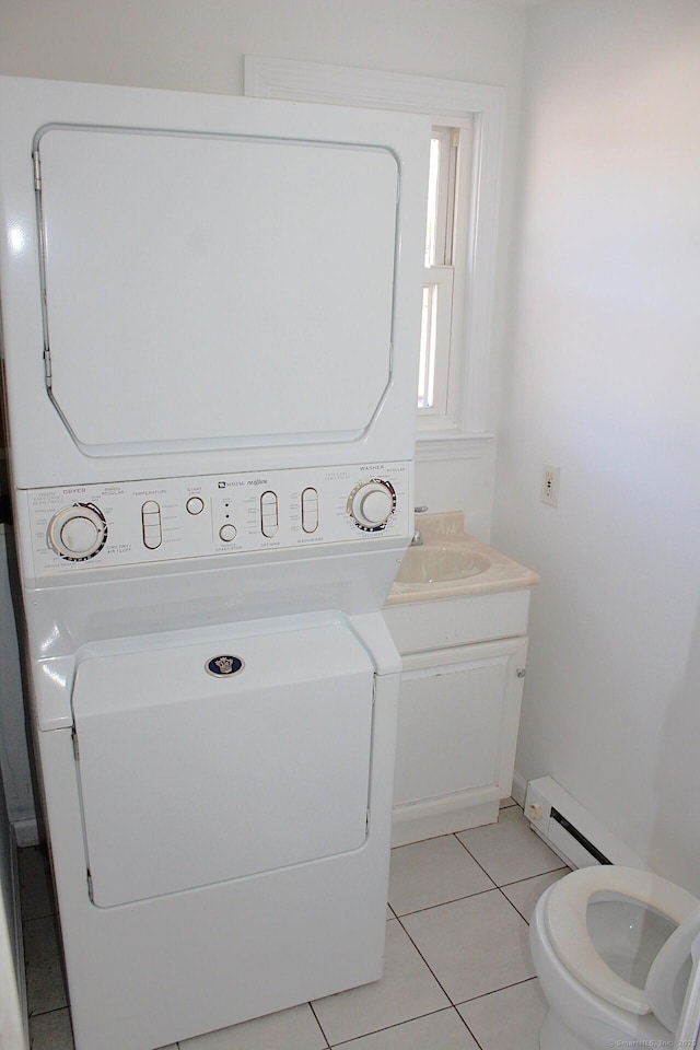 laundry area with stacked washing maching and dryer, light tile patterned floors, laundry area, and a baseboard heating unit