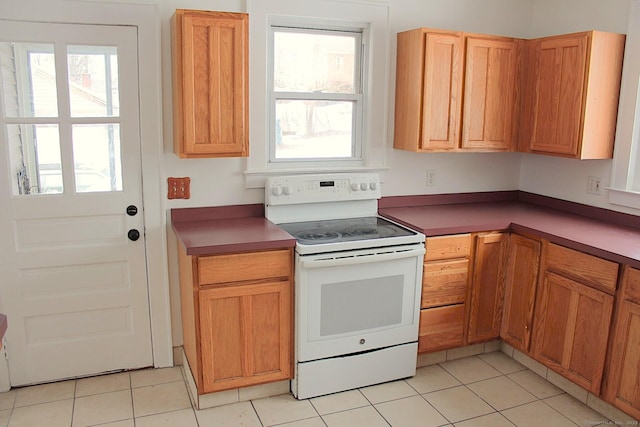 kitchen with white electric range oven and light tile patterned floors