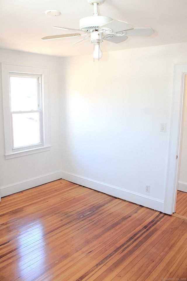 spare room with a ceiling fan, baseboards, and light wood finished floors