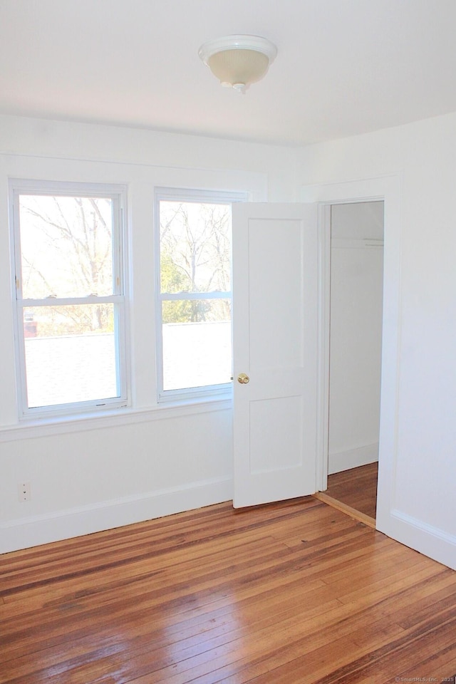 empty room featuring light wood-style flooring and baseboards