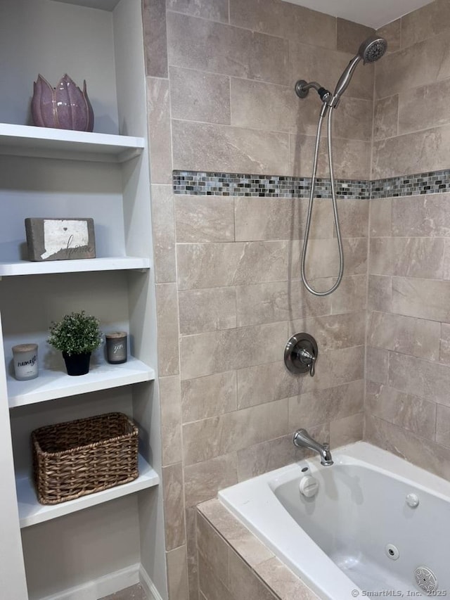 full bathroom featuring built in shelves and tiled shower / bath