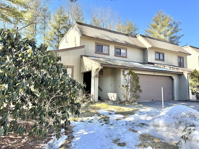 view of front facade featuring a garage, driveway, and a shingled roof