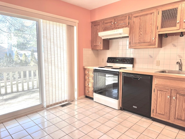 kitchen featuring under cabinet range hood, a sink, black dishwasher, light countertops, and white electric range oven