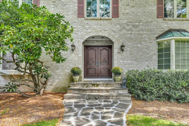 property entrance featuring brick siding