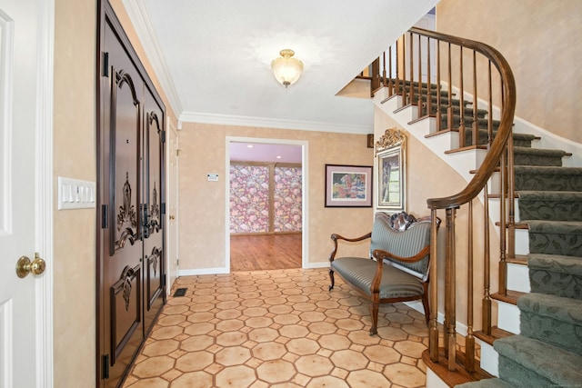 foyer entrance featuring ornamental molding, baseboards, and stairs