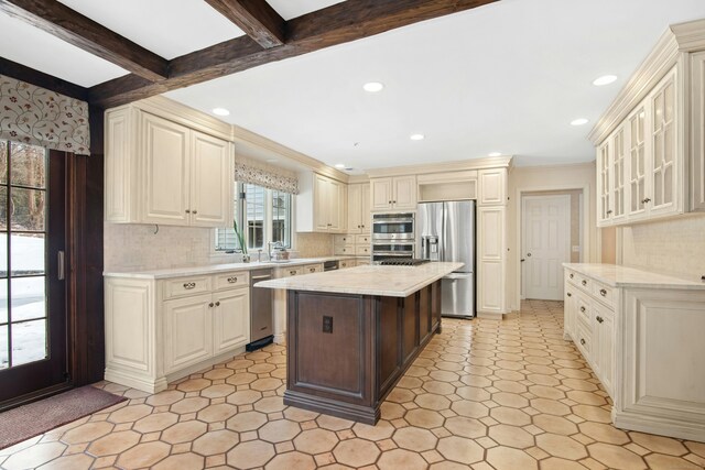 kitchen featuring a kitchen island, glass insert cabinets, backsplash, stainless steel appliances, and beam ceiling