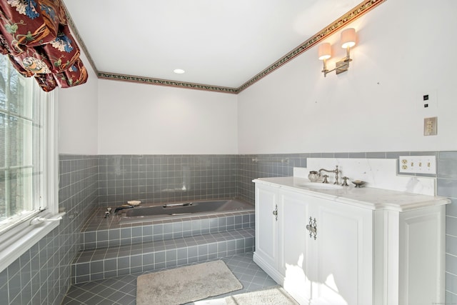 full bath with tile patterned flooring, a garden tub, vanity, and tile walls