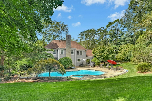 outdoor pool with a patio and a yard