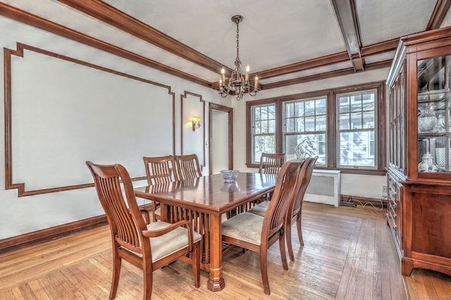 dining space featuring crown molding, a notable chandelier, light wood finished floors, radiator, and baseboards