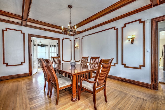 dining room with baseboards, ornamental molding, an inviting chandelier, and light wood-style floors