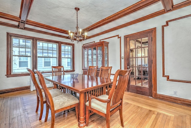 dining room with baseboards, light wood finished floors, and an inviting chandelier