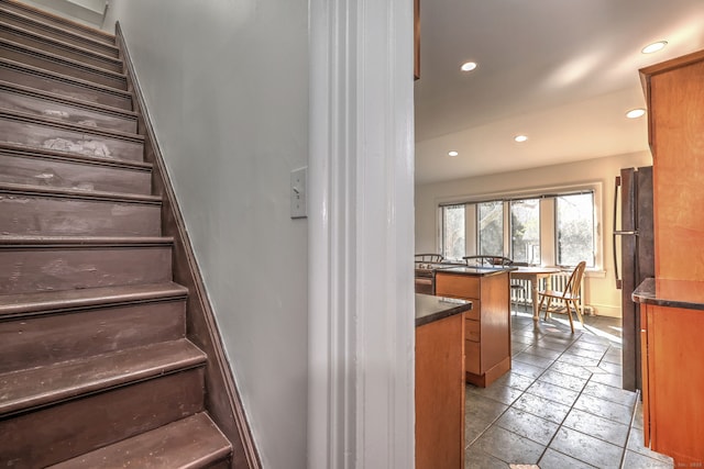 stairs featuring baseboards, stone tile flooring, and recessed lighting