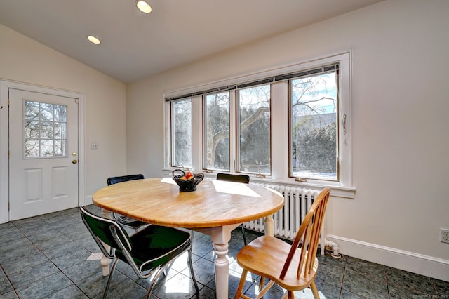 dining space featuring vaulted ceiling, a healthy amount of sunlight, recessed lighting, and radiator