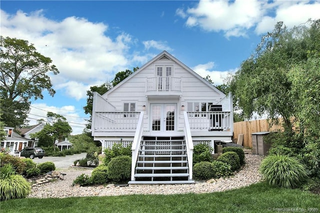 rear view of house with stairs, fence, a deck, and french doors