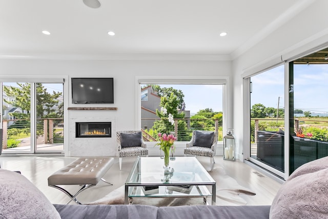living room with recessed lighting, a glass covered fireplace, and plenty of natural light