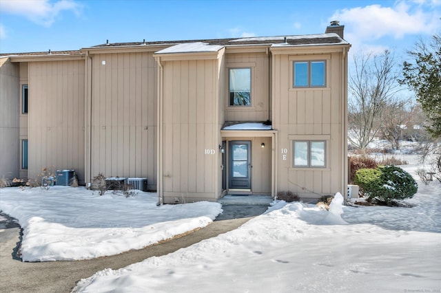 townhome / multi-family property with a chimney and board and batten siding