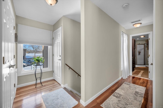 entryway with baseboards, visible vents, and wood finished floors