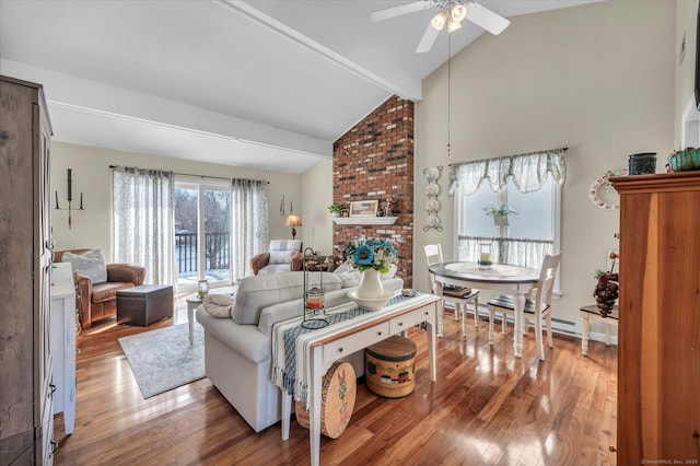 living area with beam ceiling, a ceiling fan, a brick fireplace, wood finished floors, and high vaulted ceiling