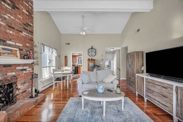 living room with a fireplace, visible vents, wood finished floors, and beamed ceiling