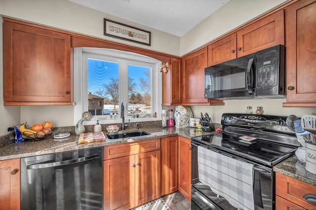 kitchen with black appliances, dark stone countertops, a sink, and brown cabinets