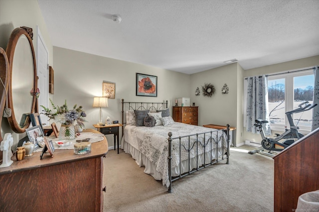 bedroom featuring baseboards, light carpet, visible vents, and a textured ceiling