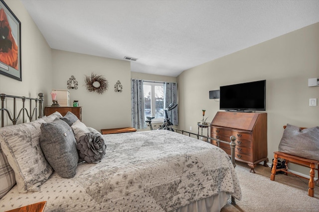 carpeted bedroom with visible vents and a textured ceiling