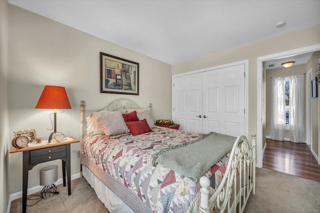 carpeted bedroom featuring a closet, visible vents, and baseboards