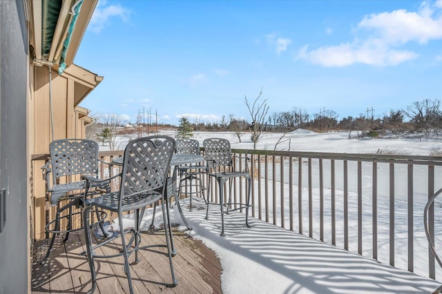 snow covered deck featuring outdoor dining space