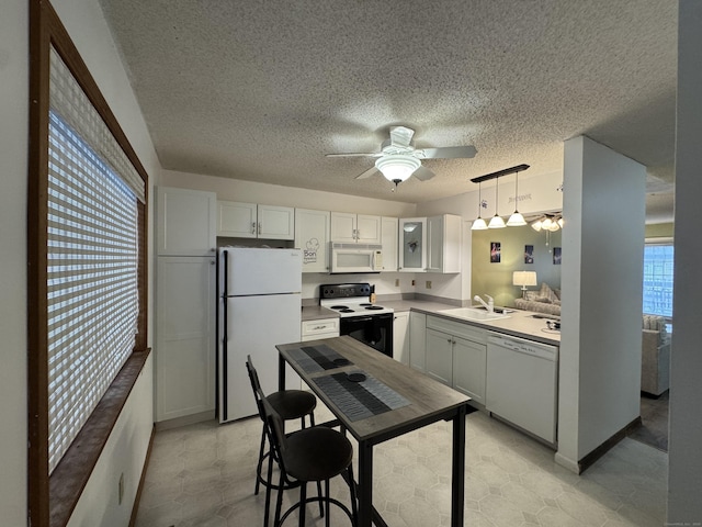 kitchen featuring ceiling fan, white appliances, a sink, white cabinets, and light countertops