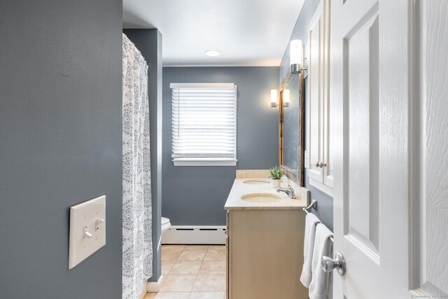 full bath featuring toilet, a sink, baseboard heating, tile patterned floors, and double vanity