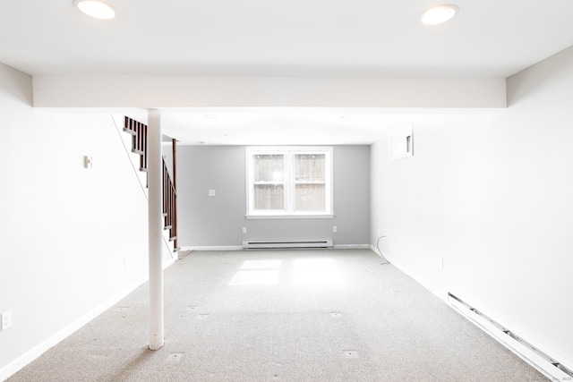 spare room with a baseboard radiator, stairway, baseboards, and light colored carpet