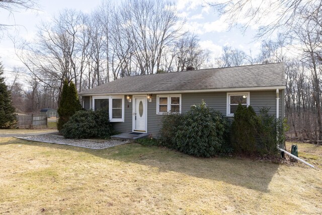 ranch-style house with a shingled roof and a front lawn