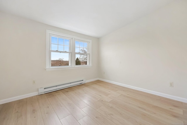 empty room with light wood-type flooring, a baseboard radiator, and baseboards