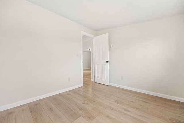 spare room featuring light wood finished floors and baseboards