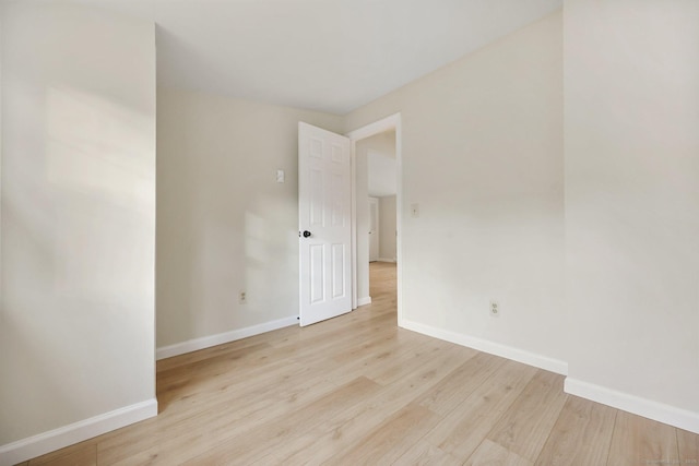 unfurnished room with light wood-style flooring and baseboards