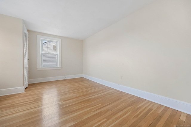 unfurnished room with light wood-style flooring and baseboards