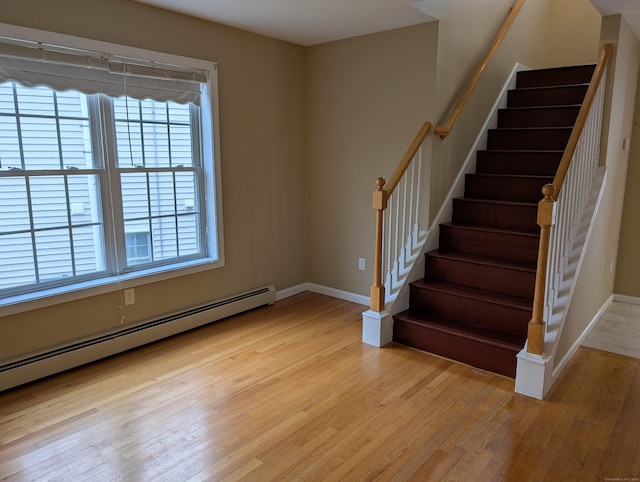 interior space featuring baseboard heating, wood finished floors, and baseboards