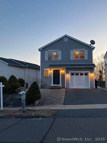 traditional-style home with a garage and aphalt driveway