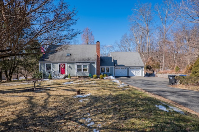 cape cod-style house with driveway, a front lawn, a chimney, and an attached garage