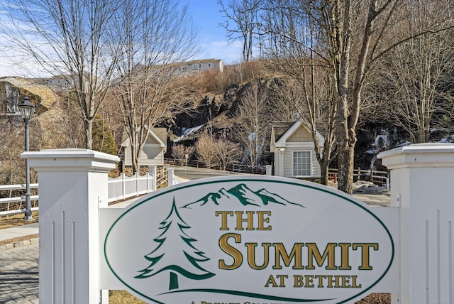 community / neighborhood sign featuring fence