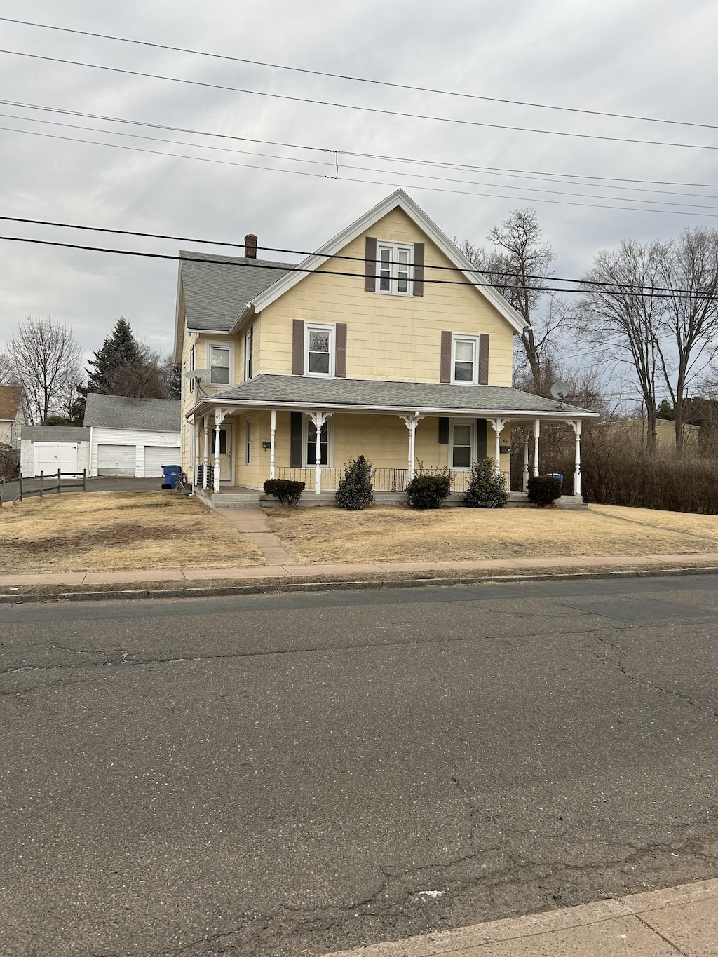 farmhouse with covered porch and fence