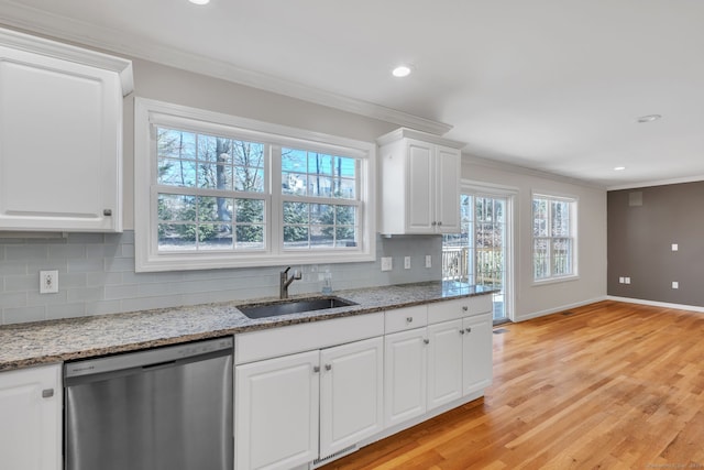 kitchen featuring stainless steel dishwasher, decorative backsplash, a sink, and crown molding