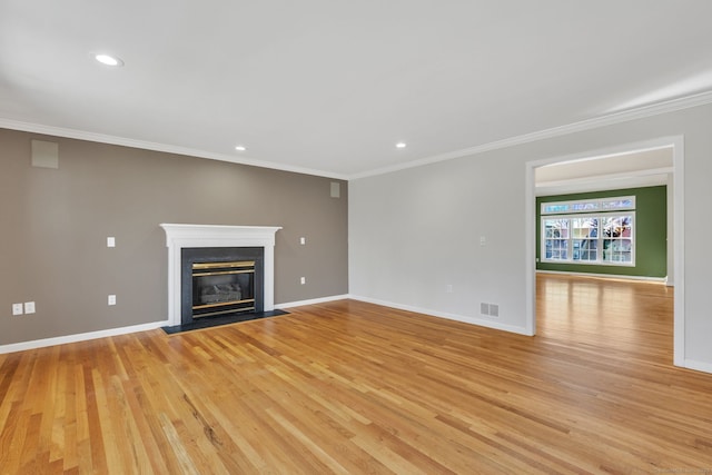 unfurnished living room featuring a fireplace with flush hearth, visible vents, ornamental molding, and baseboards